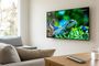 Televisor colgado en la pared de un salón mostrando un documental de naturaleza con resolución 4K.