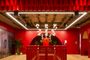 Interior de unas oficinas de Netflix con paredes rojas, techos industriales y una gran N roja al fondo.