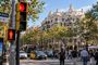 Semáforo en rojo para peatones y vehículos en el Paseo de Gracia con la Casa Milá al fondo.