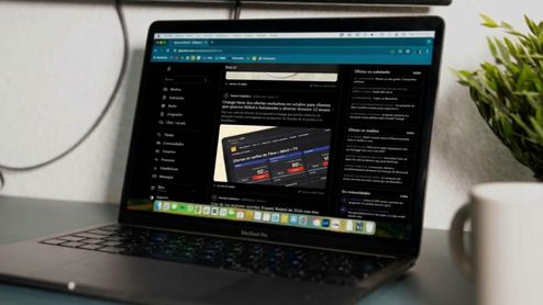 Ordenador portátil MacBook Pro mostrando el sitio web de ADSLZone en modo oscuro sobre un escritorio.