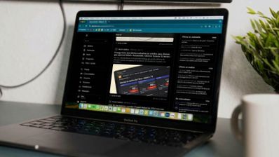 Ordenador portátil MacBook Pro mostrando el sitio web de ADSLZone en modo oscuro sobre un escritorio.