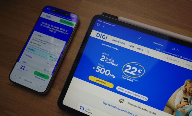Página web de DIGI abierta en una tableta y un teléfono móvil sobre una mesa de madera.