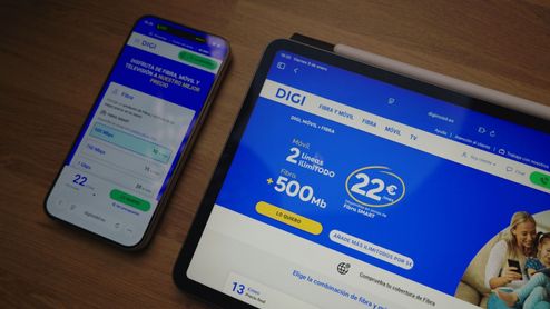Página web de DIGI abierta en una tableta y un teléfono móvil sobre una mesa de madera.