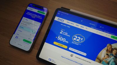 Sitio web de DIGI mostrado en las pantallas de un teléfono móvil y una tableta sobre una mesa de madera.