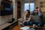 Pareja en un salón frente a un televisor que muestra un mensaje de error de conexión junto a un router DIGI.