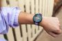 Primer plano de una persona consultando la pantalla de un reloj deportivo Garmin Forerunner 165 en su muñeca.