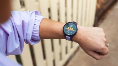 Primer plano de una persona consultando la pantalla de un reloj deportivo Garmin Forerunner 165 en su muñeca.