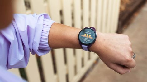 Primer plano de una persona consultando la pantalla de un reloj deportivo Garmin Forerunner 165 en su muñeca.