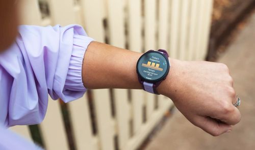 Primer plano de una persona consultando la pantalla de un reloj deportivo Garmin Forerunner 165 en su muñeca.