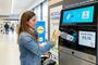 Mujer introduciendo una botella de plástico en una máquina de reciclaje con sistema de recompensa en un supermercado Lidl.