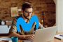 Hombre con gafas trabajando con un ordenador portátil frente al logotipo de Movistar superpuesto.