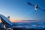 Satélite en órbita enviando señales de datos a una antena parabólica terrestre durante el atardecer.