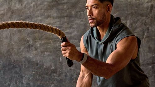 Hombre realizando ejercicio de cuerdas de batalla con un dispositivo Garmin Cirqa en la muñeca.