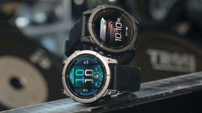 Dos relojes Garmin Fenix E con esferas digitales y correas negras en un entorno de gimnasio.
