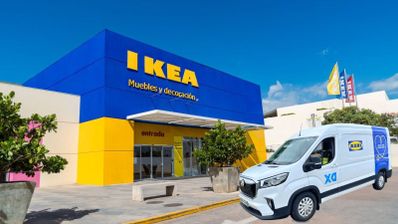 Fachada de una tienda IKEA de color azul y amarillo con una furgoneta de reparto blanca en primer plano.