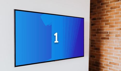 Televisión de pantalla plana colgada en una pared blanca con el logotipo del canal La 1 de TVE.