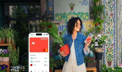 Interfaz de la aplicación Monzo Bank en un teléfono móvil junto a una mujer en una floristería.