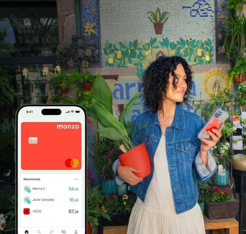 Interfaz de la aplicación Monzo Bank en un teléfono móvil junto a una mujer en una floristería.