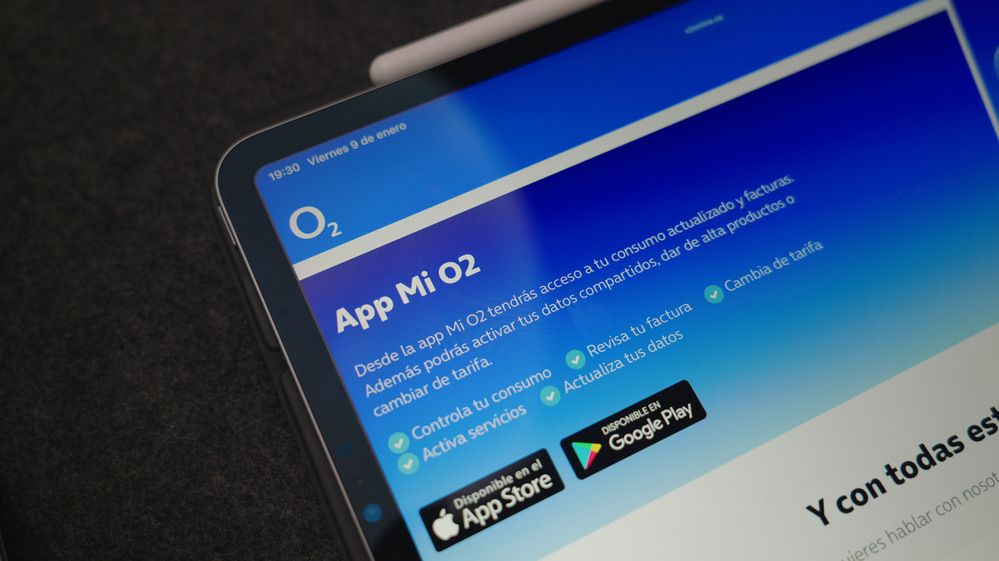 Interfaz de la aplicación Mi O2 en la pantalla de una tableta con enlaces de descarga para iOS y Android.