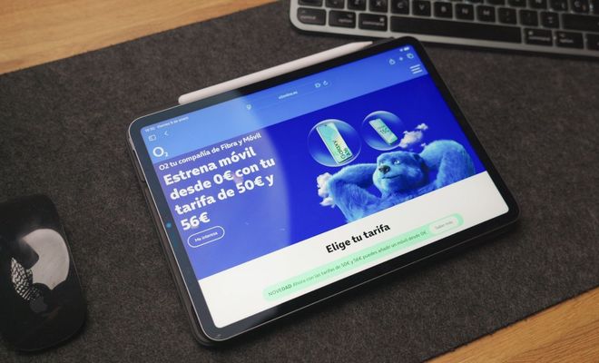 Tableta sobre un escritorio que muestra la página web de O2 con ofertas de fibra y móvil.