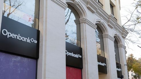 Fachada de una oficina de Openbank con logotipos en los ventanales.