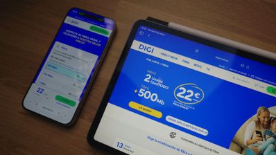 Página web del operador DIGI abierta en un teléfono móvil y una tableta sobre una mesa de madera.