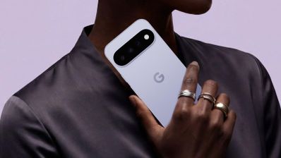Parte trasera de un smartphone blanco con tres cámaras y el logotipo de Google sostenido por una mano.
