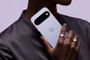 Parte trasera de un smartphone blanco con tres cámaras y el logotipo de Google sostenido por una mano.