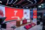 Estudio de televisión de La Séptima con gran pantalla curva roja, mesa central y cámaras de producción.