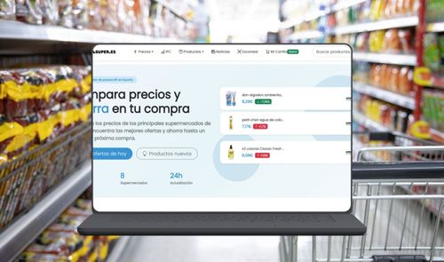 Interfaz de la web Preciosdelsuper en un ordenador portátil frente a un pasillo de supermercado.