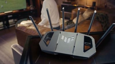 Router inalámbrico con seis antenas externas y logotipo frontal en un salón doméstico.