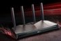 Router TP-Link con cuatro antenas externas y chasis geométrico oscuro sobre fondo de líneas de luz roja.