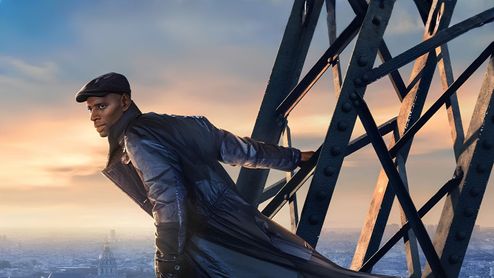 Omar Sy como Assane Diop sujetado a la estructura metálica de la Torre Eiffel con la ciudad de París al fondo.