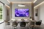 Televisor Samsung Crystal UHD instalado en la pared de un salón comedor moderno con iluminación cálida.