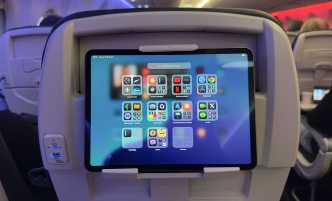 Tableta sujeta en el respaldo de un asiento de avión de easyJet mostrando iconos de aplicaciones.