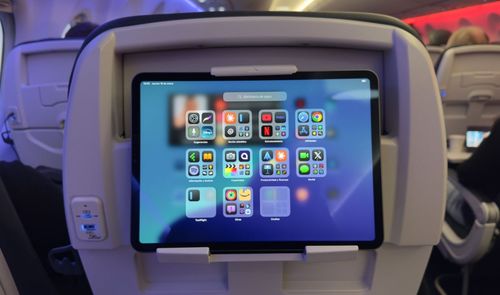 Tableta sujeta en el respaldo de un asiento de avión de easyJet mostrando iconos de aplicaciones.