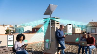Varias personas utilizan dispositivos electrónicos en una terraza con una antena de Starlink instalada en una chimenea.