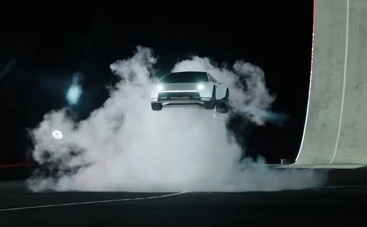 Un Tesla Roadster elevándose en el aire rodeado de una densa nube de humo blanco en un escenario oscuro.
