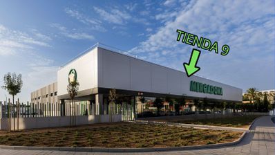 Fachada exterior de un supermercado Mercadona con una flecha verde señalando el rótulo y el texto Tienda 9.