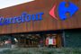 Fachada de un establecimiento Carrefour con un camión de bomberos estacionado en el acceso inferior.