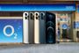 Fachada de una tienda física de O2 con un montaje publicitario de varios modelos de iPhone en diferentes colores.