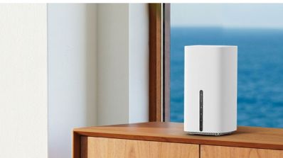 Router inalámbrico TP-Link Archer de color blanco con formato de torre vertical sobre un mueble de madera junto a una ventana.