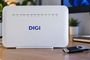 Router ZTE F6705 de Digi con indicadores LED verdes encendidos sobre una mesa de madera.